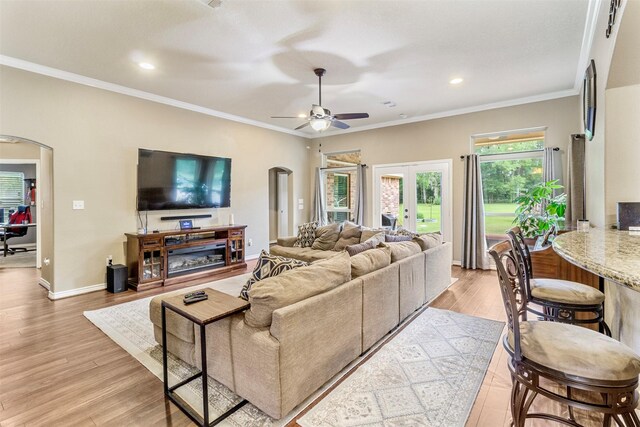 living room featuring ceiling fan, french doors, light hardwood / wood-style flooring, and ornamental molding