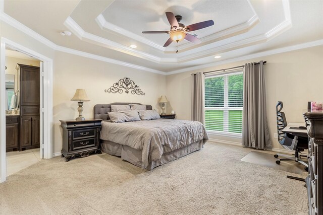 carpeted bedroom with ornamental molding, ensuite bathroom, ceiling fan, and a raised ceiling