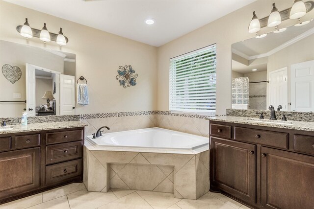 bathroom with tiled tub, dual vanity, tile patterned flooring, and crown molding