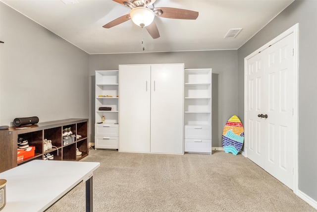 carpeted office space featuring ceiling fan