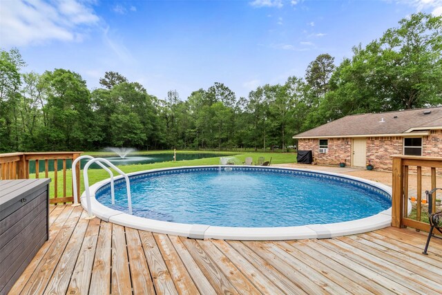 view of swimming pool featuring a lawn and a wooden deck