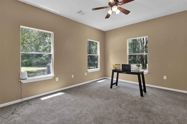 unfurnished office with ceiling fan, carpet floors, and plenty of natural light