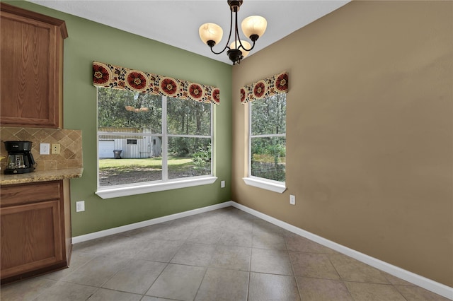 unfurnished dining area with light tile patterned flooring and an inviting chandelier