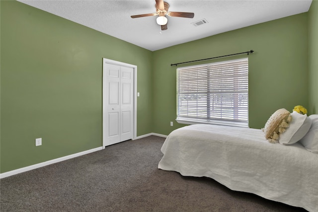 carpeted bedroom featuring ceiling fan, a textured ceiling, and a closet