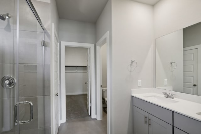 bathroom featuring vanity, tile patterned flooring, a shower with shower door, and toilet