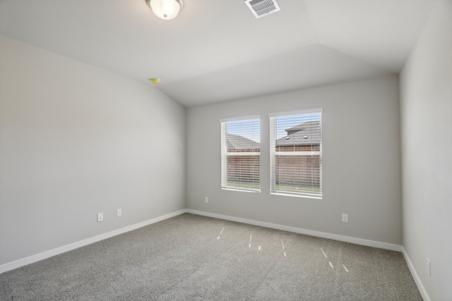 carpeted spare room with lofted ceiling