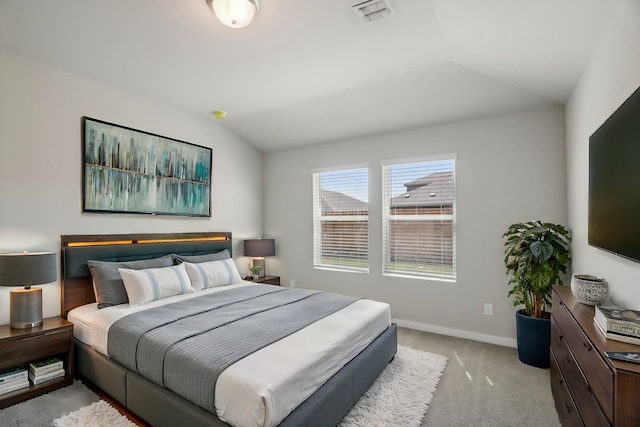 bedroom featuring lofted ceiling and light carpet