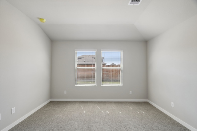 carpeted spare room with vaulted ceiling