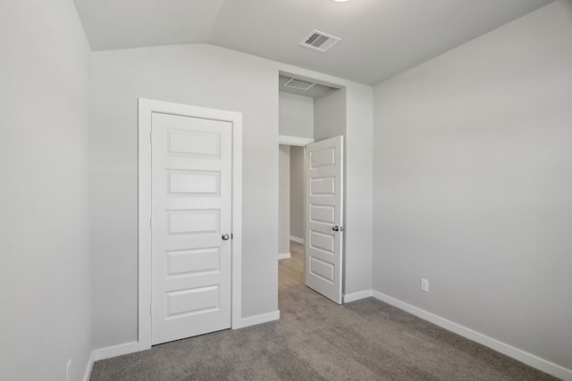 unfurnished bedroom featuring lofted ceiling and light colored carpet