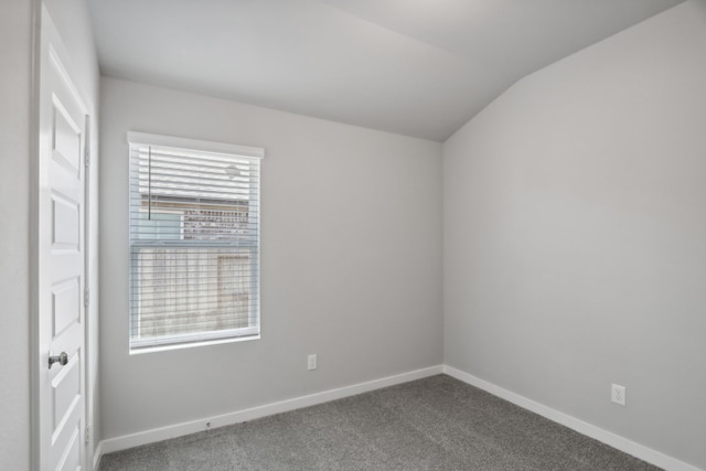 unfurnished room featuring carpet flooring and vaulted ceiling