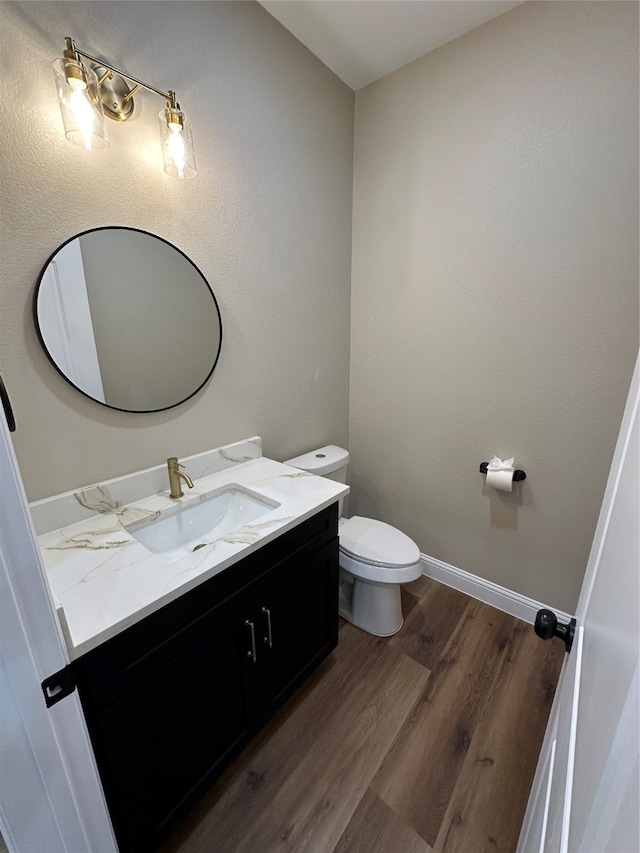 bathroom with hardwood / wood-style floors, vanity, and toilet