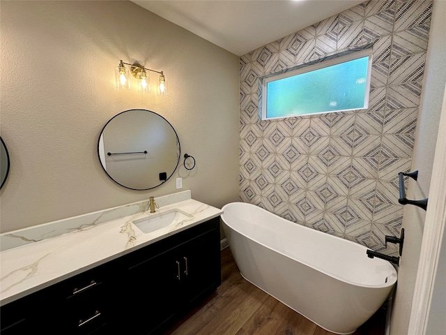 bathroom with vanity, a tub to relax in, and hardwood / wood-style floors