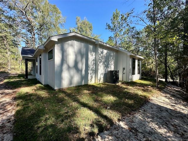 view of home's exterior with cooling unit and a yard