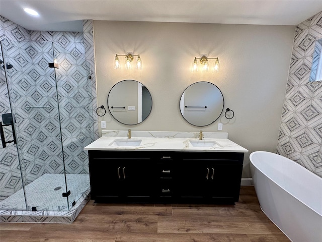 bathroom with shower with separate bathtub, vanity, tile walls, and hardwood / wood-style floors