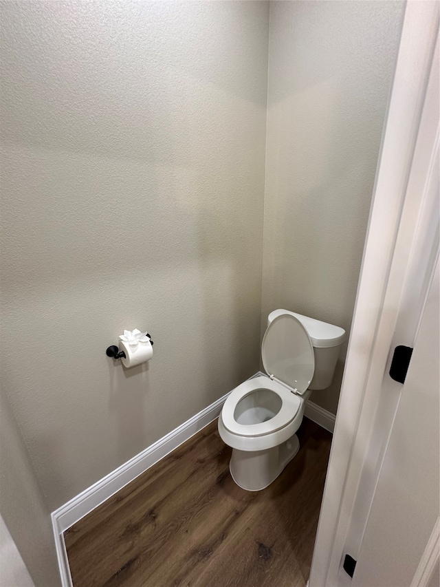 bathroom with hardwood / wood-style floors and toilet