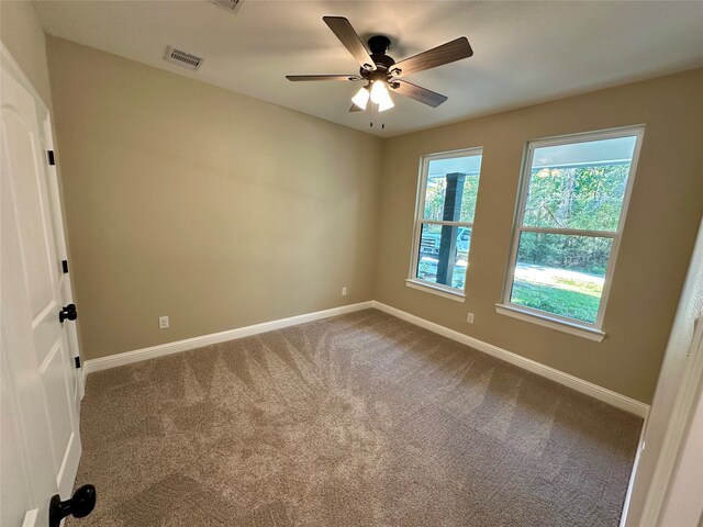 carpeted spare room featuring ceiling fan