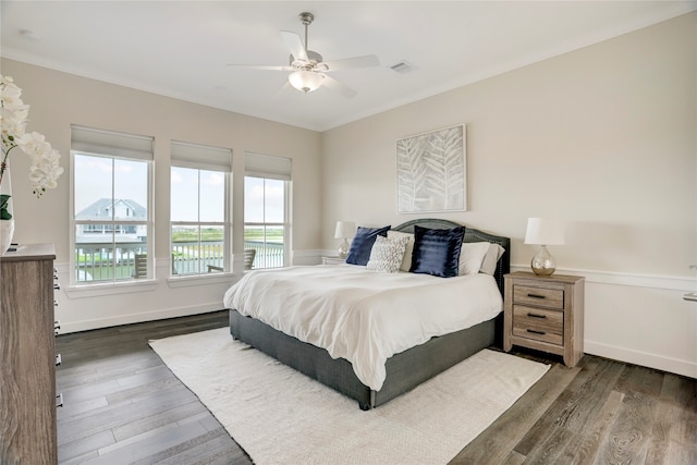 bedroom featuring ornamental molding, dark wood-type flooring, and ceiling fan