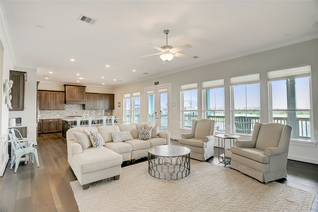 living room featuring ornamental molding, light hardwood / wood-style floors, a healthy amount of sunlight, and ceiling fan