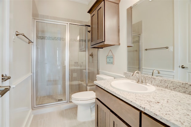 bathroom with tile patterned flooring, vanity, toilet, and a shower with door