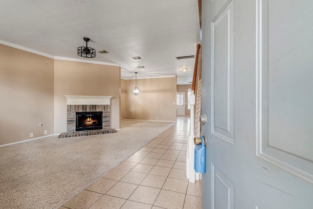 unfurnished living room featuring crown molding, a textured ceiling, light tile patterned flooring, and a brick fireplace