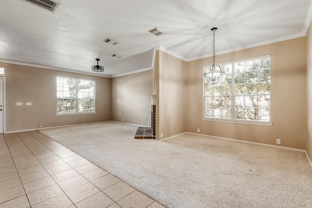 unfurnished living room with light carpet, a notable chandelier, a textured ceiling, and ornamental molding