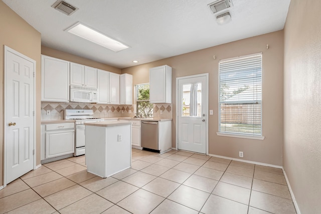 kitchen with a kitchen island, decorative backsplash, white cabinets, and white appliances