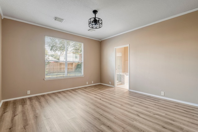 spare room with light hardwood / wood-style floors, ornamental molding, and a textured ceiling