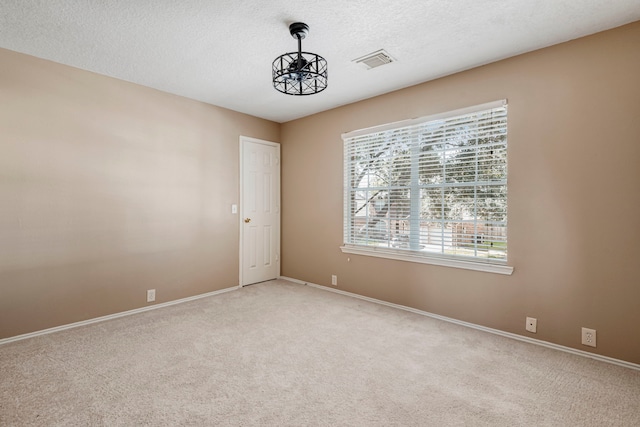 carpeted spare room featuring a textured ceiling