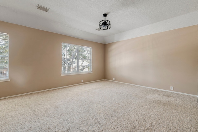 carpeted empty room with a textured ceiling