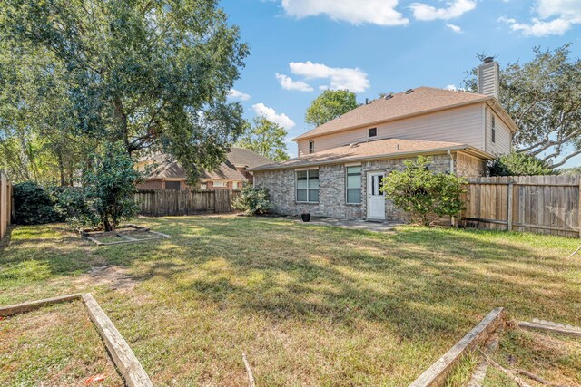 rear view of house featuring a lawn