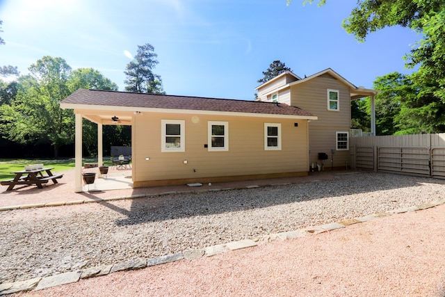 rear view of property with ceiling fan and a patio