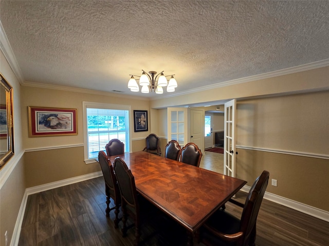 dining space with dark hardwood / wood-style floors, ornamental molding, a textured ceiling, and french doors