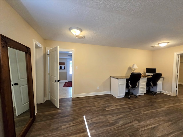 home office featuring dark hardwood / wood-style floors and a textured ceiling