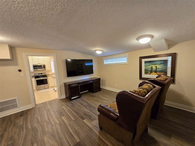 living room with a textured ceiling and dark wood-type flooring