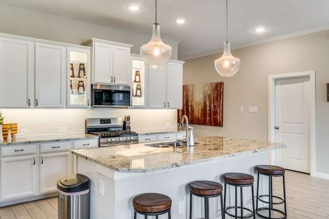 kitchen with backsplash, a kitchen island with sink, and stainless steel appliances