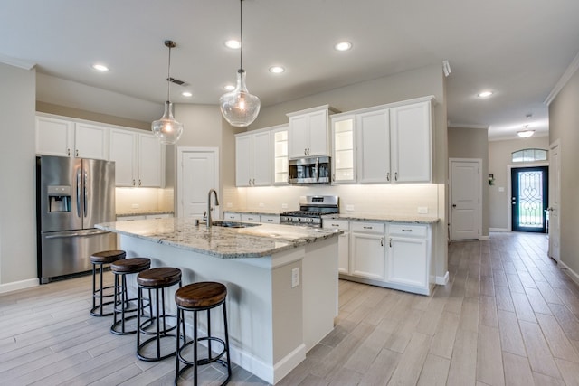 kitchen featuring backsplash, stainless steel appliances, sink, and white cabinetry