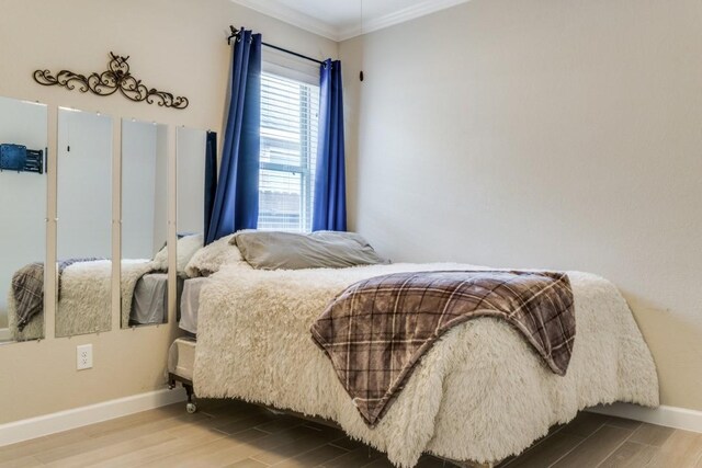 bedroom with crown molding and wood-type flooring