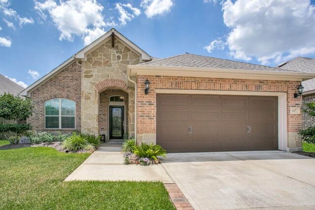 view of front of property with a garage and a front lawn