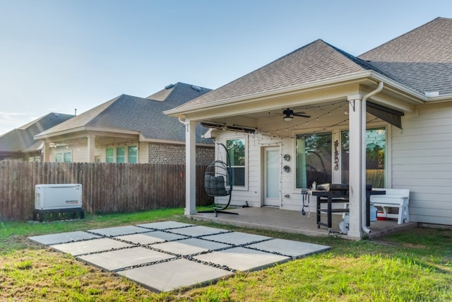 back of property featuring ceiling fan, a lawn, and a patio