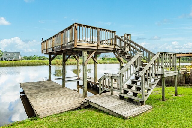 dock area featuring a deck with water view and a yard