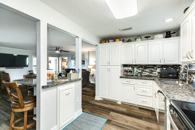131 Bastrop Bayou Dr, Angleton, TX 77515 - kitchen with dark stone countertops, white cabinets, a textured ceiling, visible vents, and dark wood-style flooring