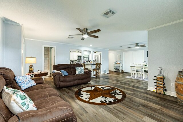 131 Bastrop Bayou Dr, Angleton, TX 77515 - living room featuring a ceiling fan, crown molding, visible vents, and wood finished floors