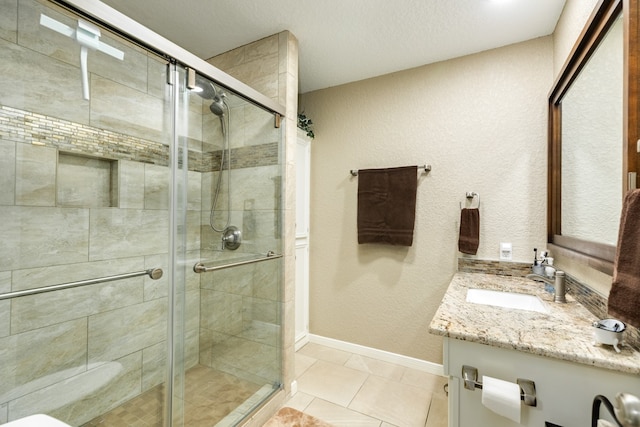 bathroom with an enclosed shower, vanity, and tile patterned flooring