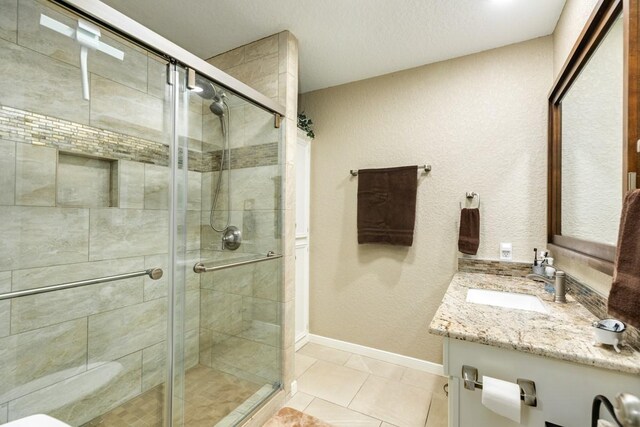 131 Bastrop Bayou Dr, Angleton, TX 77515 - bathroom featuring tile patterned flooring, baseboards, a shower stall, and vanity