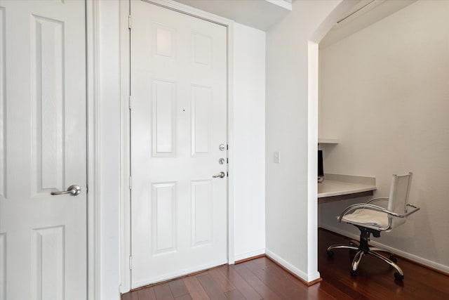 office space with built in desk and dark hardwood / wood-style floors