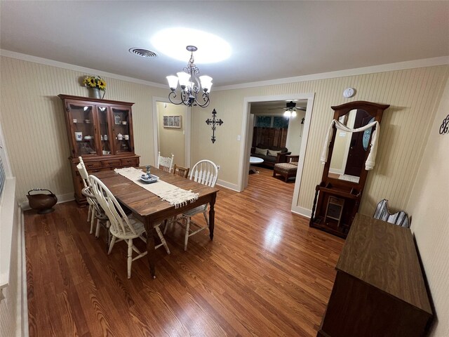 dining area with ceiling fan with notable chandelier, ornamental molding, and hardwood / wood-style floors