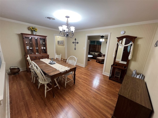 dining room with an inviting chandelier, ornamental molding, and dark hardwood / wood-style flooring