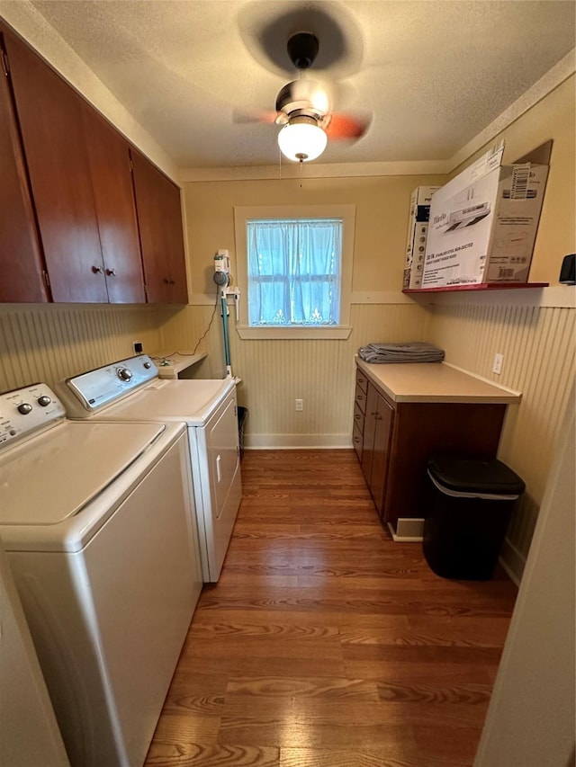 laundry room with dark hardwood / wood-style flooring, cabinets, ceiling fan, washing machine and dryer, and a textured ceiling