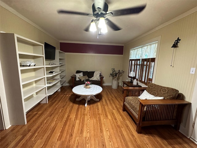 living area with hardwood / wood-style flooring, ornamental molding, and ceiling fan