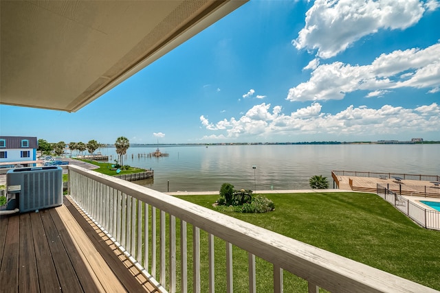 wooden deck with a lawn, cooling unit, and a water view